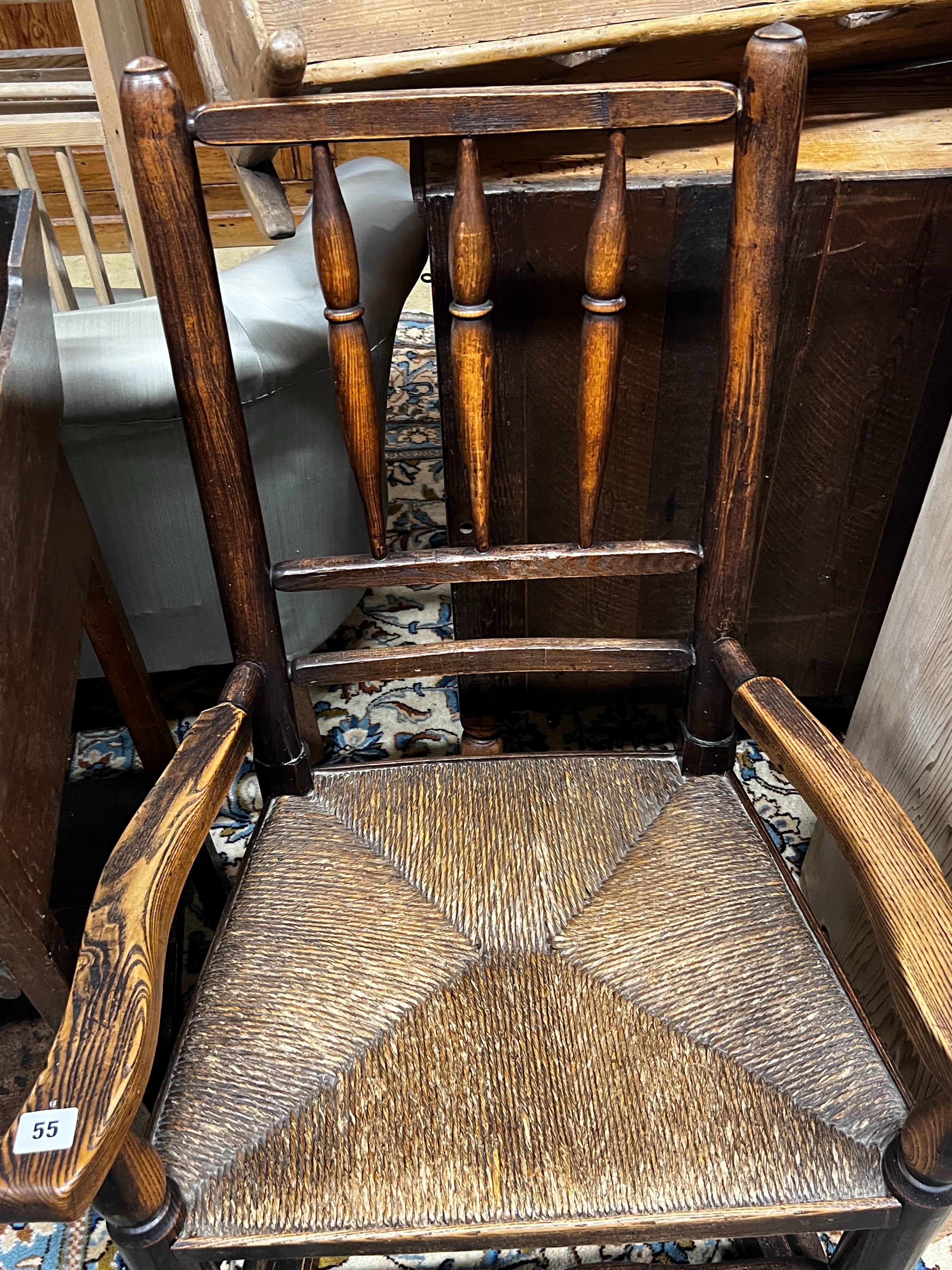 An early 19th century ash rush seat spindle back rocking chair, width 60cm, depth 46cm, height 94cm